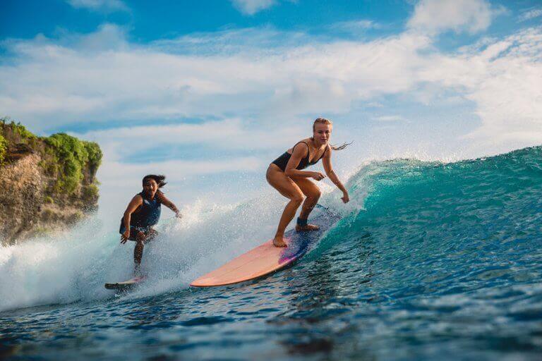 Two people surfing in the Polynesian sea