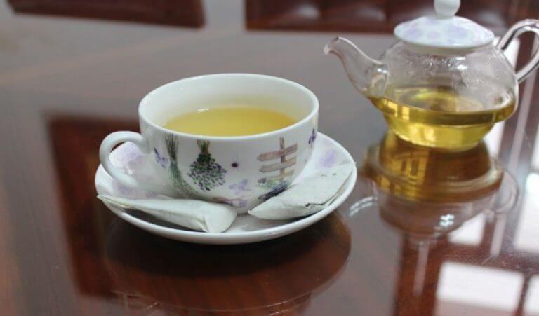 A cup of tea next to a hot kettle