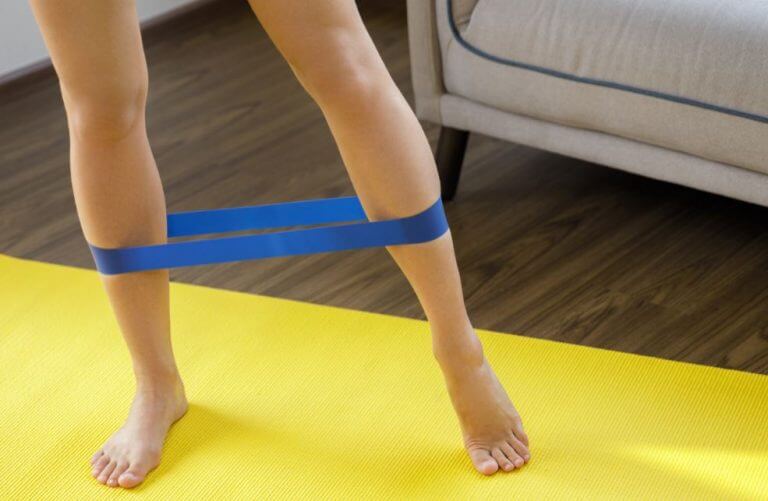 A woman using a resistance band to improve her leg workout