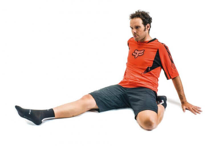 A man doing calf stretches on the floor