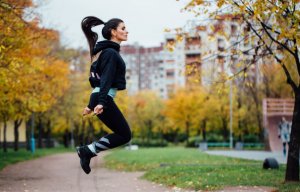 A woman jumping rope outside.