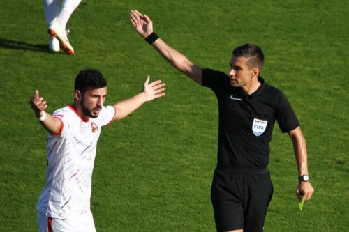 A referee explaining to a player to support the explanation in the text