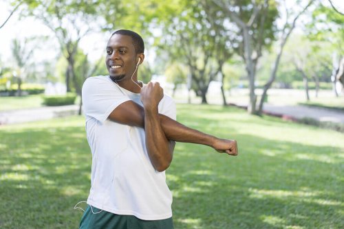 A man doing muscle stretches for his arms.