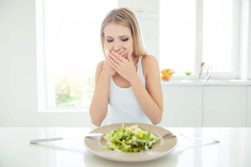Young woman with hands over her mouth to support test about anorexia