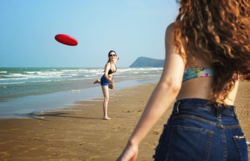 Two women throwing a frisbee around.