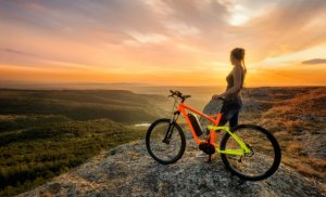A woman on a hill with her bike.