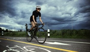 A woman riding a bike in stormy weather.
