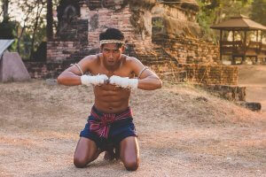 A kneeling Muay Thai fighter.