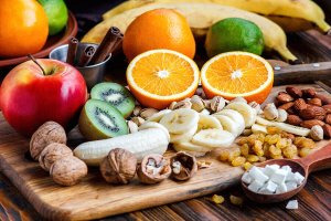 Fruit and nuts on a cutting board.