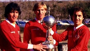 Soccer players holding their trophy.