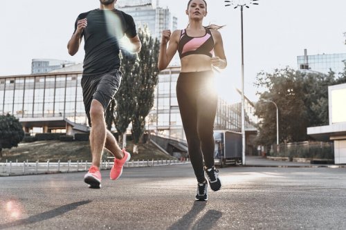 A couple jogging on the pavement which involves muscle tissue.