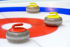 Three curling stones on the ice.