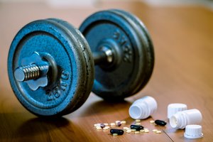 A dumbbell with bottles of pills.