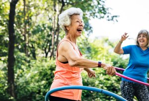 Two older women playing with hula hoops.