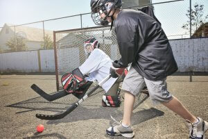 Two children playing street hockey.