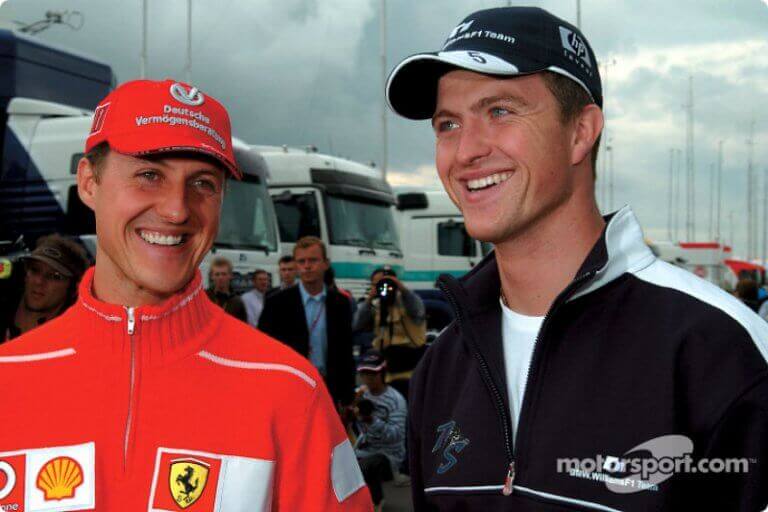 The Schumacher brothers wearing their racing outfits and smiling