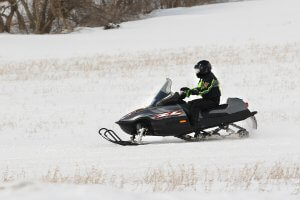 A motor sledder races across the snow.
