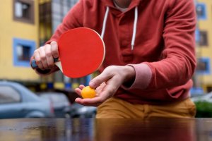 A person about to serve the ball in a game of table tennis.