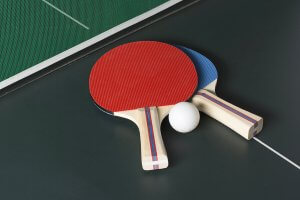 Two table tennis paddles and a ball.
