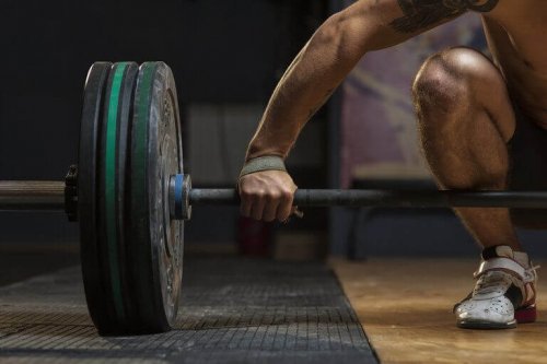 A guy lifting a dumbell to build muscle tissue.