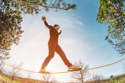 A guy practicing slacklining.