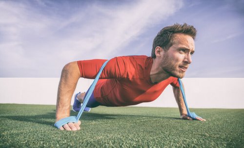 A guy working out with resistance bands.