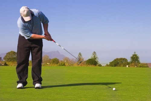 A man swinging, with physical preparation for golf.