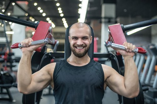 A happy guy lifting weights.