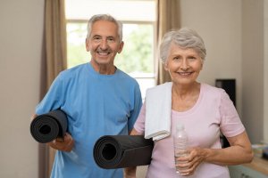 An older couple with yoga mats.