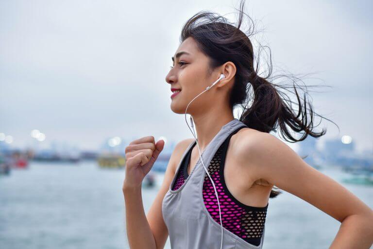 A woman running while wearing her headphones