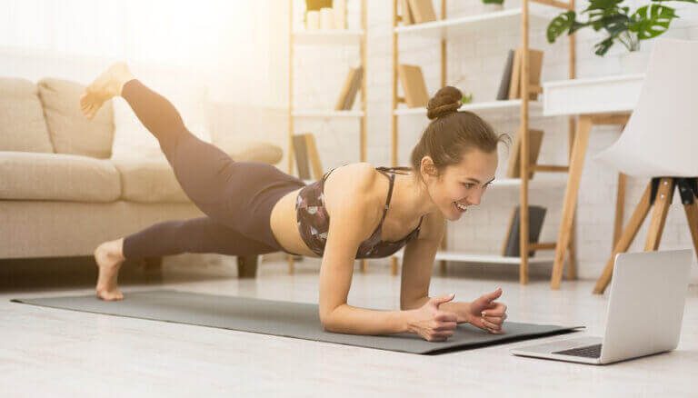 A woman working out at home while following videos from different fitness channels