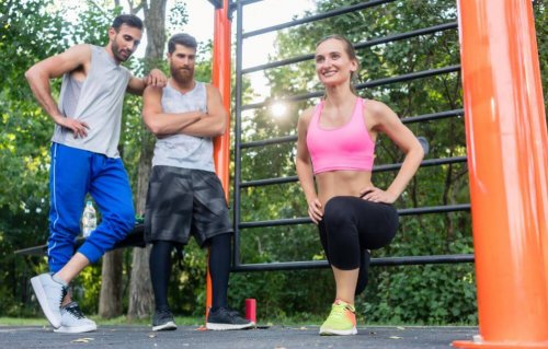 Two guys watching a woman do a lunge.