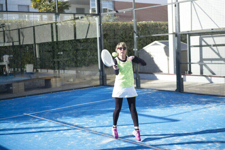 An older woman playing tennis after a transplant