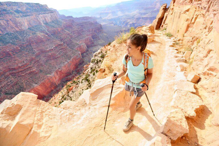 A woman trekkking and enjoying the view from the top of a cannyon