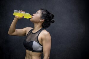 A woman drinking an energy drink.