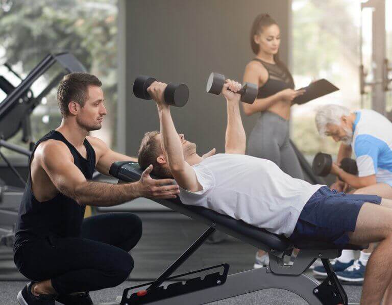 A man training with weights at the gym to increase his calorie expenditure