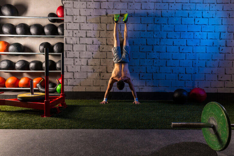 A man doing a handstand push up against the wall