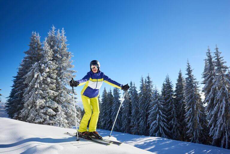 A happy woman skiing down a beginner slope