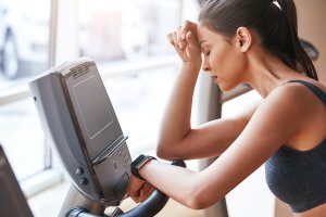 Woman with muscle fatigue working out.