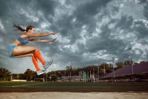 A female athlete performing a long jump, which is one of the most well-known jumping sports.