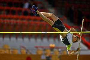 A female athlete performing a pole vault, which is one of the main jumping sports.