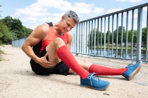 A man sitting on the ground because of thigh injuries.