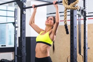 A woman learning to do pull-ups.