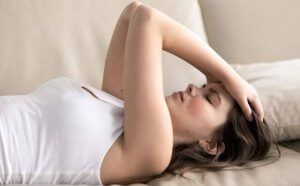 A woman lying on the sofa annoyed.