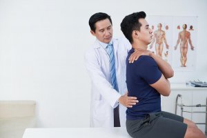 An athlete having his back checked by the doctor.