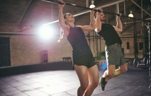 Two people doing pull-ups together.