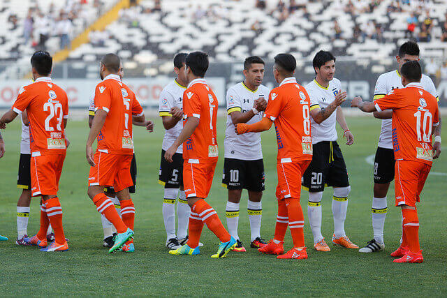 Members of the Colo-Colo and the Cobreola team greeting each other before disputing of the classic encounters of Chilean soccer