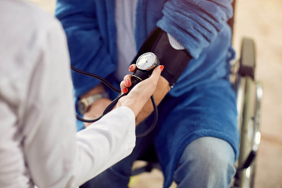 A doctor measuring the blood pressure levels of a hypertensive person to see if they can get started with sports