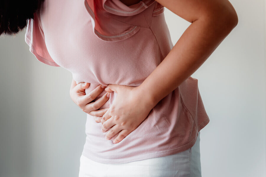 A woman holding her abdomen because she is in pain