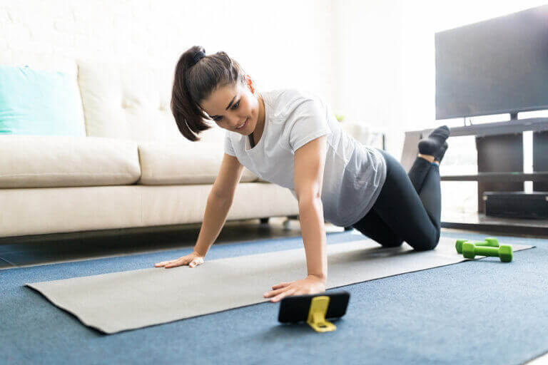 A woman using an exercise mat to work out at home